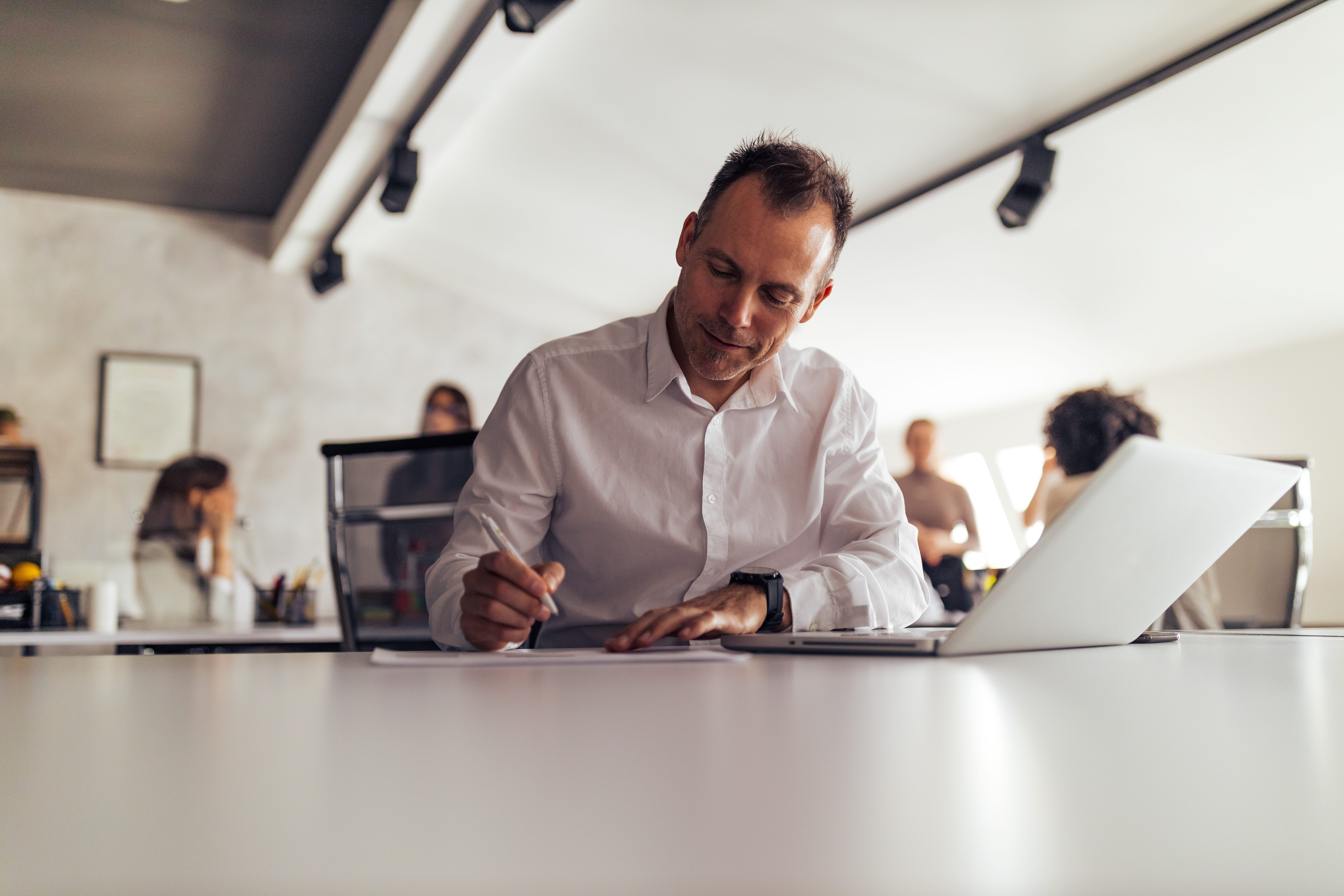 Business man writing notes at work.