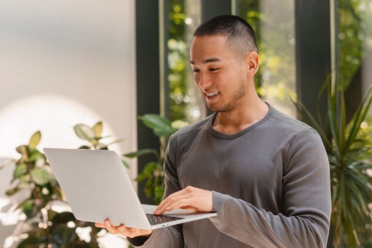 man standing with laptop